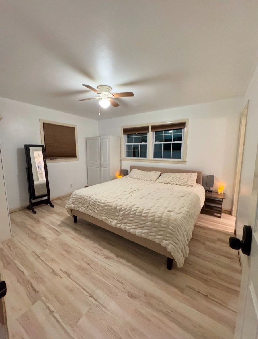 Recámara con cama king y pisos de madera clara