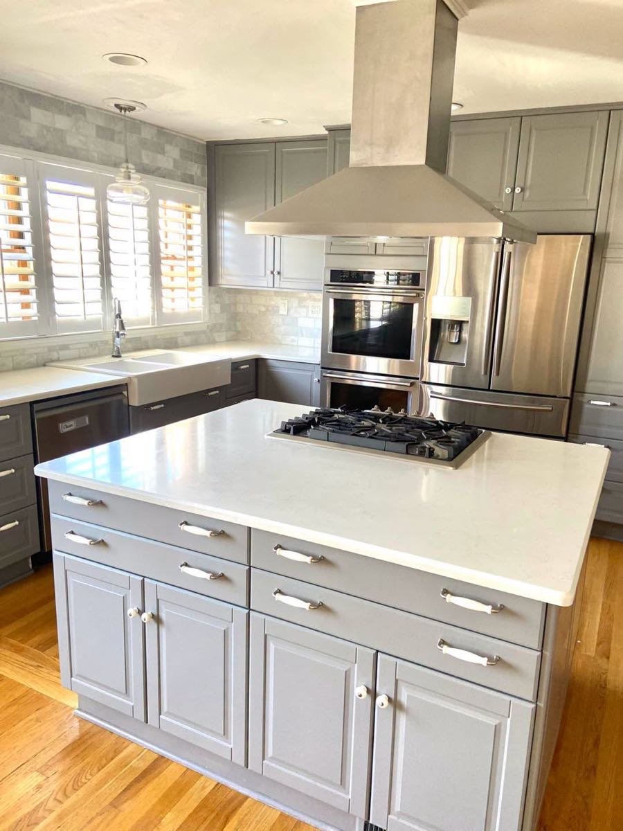 Gray kitchen with a quartz island and gas cooktop