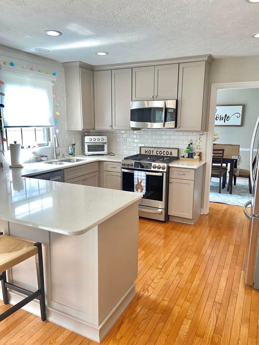 Cocina con península de cuarzo y pisos de madera