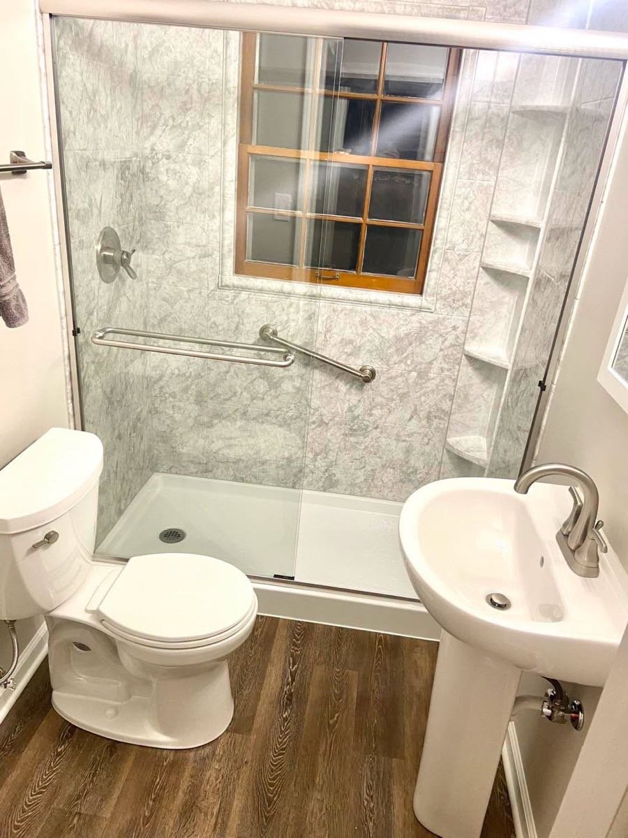 Baño con regadera amplia y lavabo de pedestal